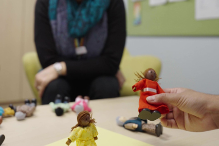 A person picking up toy figurines that are laying on a table 