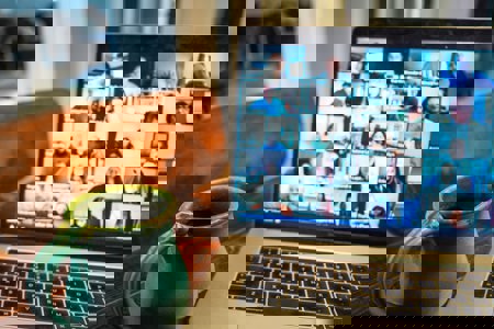 A coffee mug sitting next to an open laptop on a brown wooden table