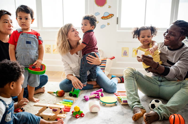 Happy parents embracing their toddler. They're outdoors and the light is golden