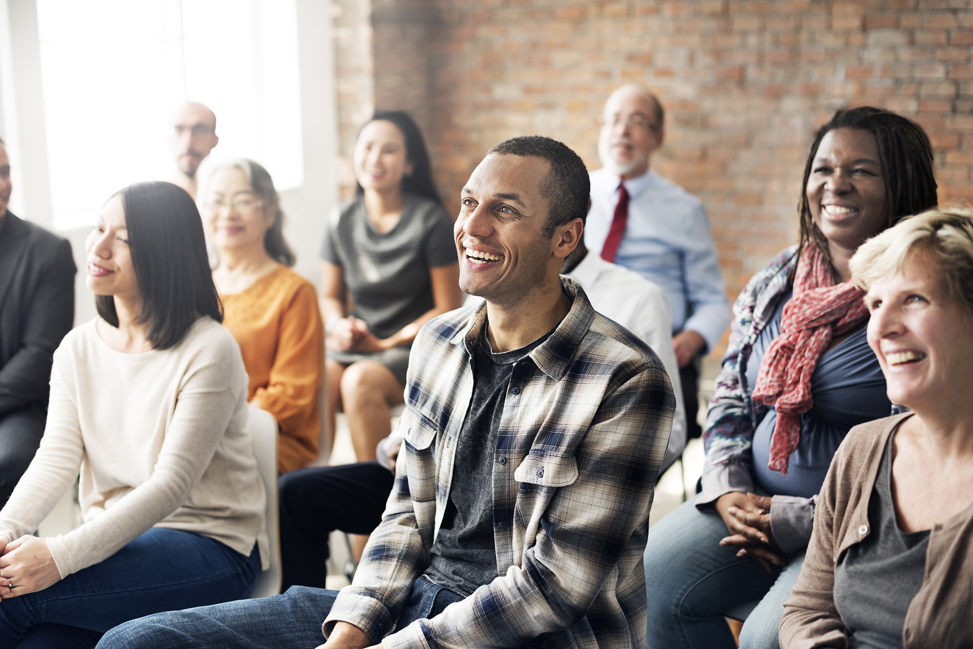 A large classroom full of people smiling while looking off into the distance