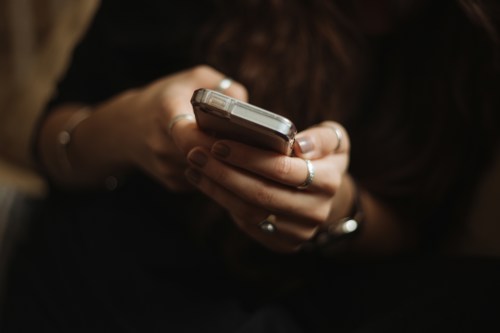 A close-up of a person's hands using a mobile phone
