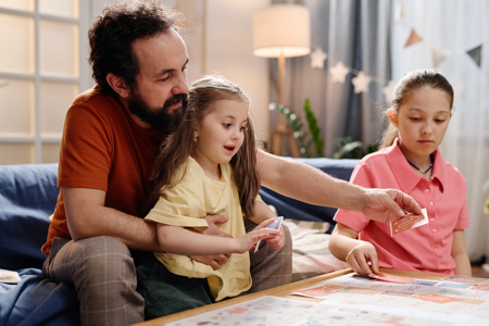 A father playing at a coffee table with his 2 children